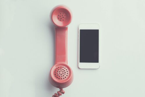 analog phone and smartphone next to each other